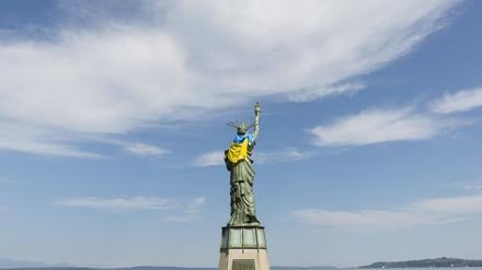 Die Freiheitsstatue auf dem Statue of Liberty Plaza in Seattle ist mit der Flagge der Ukraine geschmückt, während sich eine kleine Gruppe von Unterstützern zu einer Ukraine Freedom Rally am 25. August 2025 versammelt.