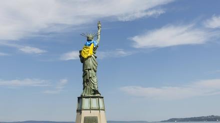 Die Freiheitsstatue auf dem Statue of Liberty Plaza in Seattle ist mit der Flagge der Ukraine geschmückt, während sich eine kleine Gruppe von Unterstützern zu einer Ukraine Freedom Rally am 25. August 2025 versammelt.