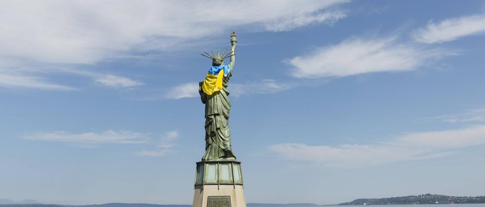 Die Freiheitsstatue auf dem Statue of Liberty Plaza in Seattle ist mit der Flagge der Ukraine geschmückt, während sich eine kleine Gruppe von Unterstützern zu einer Ukraine Freedom Rally am 25. August 2025 versammelt.