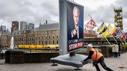 Ein Arbeiter stellt in Den Haag eine Wahlwerbung von Geert Wilder auf.