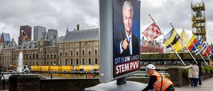 Ein Arbeiter stellt in Den Haag eine Wahlwerbung von Geert Wilder auf.