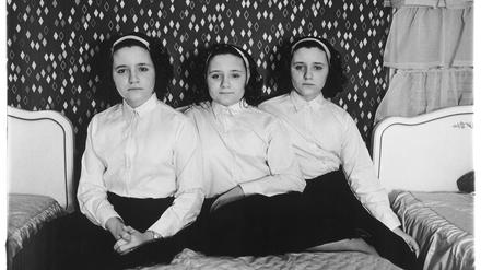 Diane Arbus betitelte ihre Bilder mit faktischen Informationen zu den Porträtierten: „Drillinge in ihrem Schlafzimmer, N.J. 1963“.