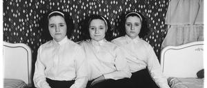 Diane Arbus betitelte ihre Bilder mit faktischen Informationen zu den Porträtierten: „Drillinge in ihrem Schlafzimmer, N.J. 1963“.