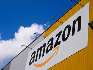 Das Logo des Online-Händlers Amazon ist an der großen Lagerhalle seines Logistikzentrums zu sehen.