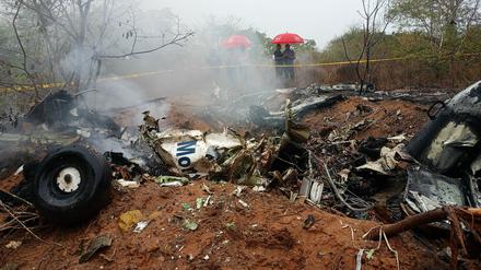  Kenianische Beamte inspizieren die Absturzstelle eines Flugzeugs in der Nähe von Diani. 