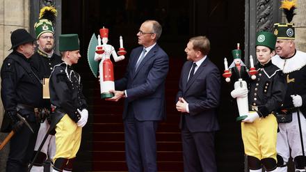 Kanzler Friedrich Merz wird von Vertretern des Bergmannsmusikkorps Sachsen in Dresden begrüßt.