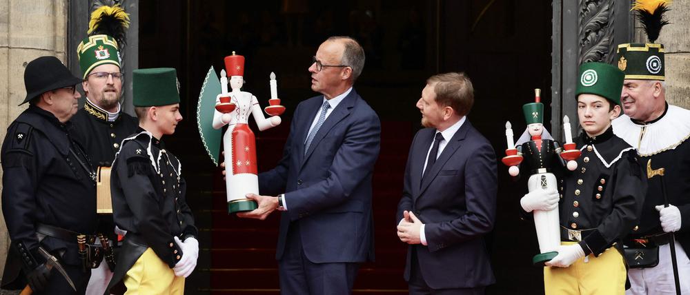 Kanzler Friedrich Merz wird von Vertretern des Bergmannsmusikkorps Sachsen in Dresden begrüßt.