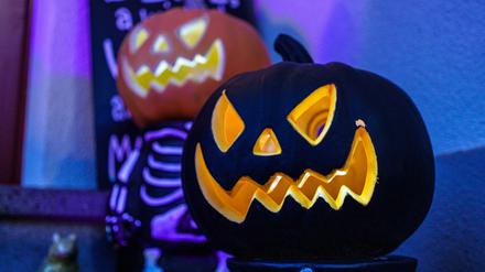 Geschnitzte Halloweenfratzen in Kürbissen.