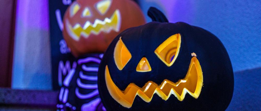 Geschnitzte Halloweenfratzen in Kürbissen.