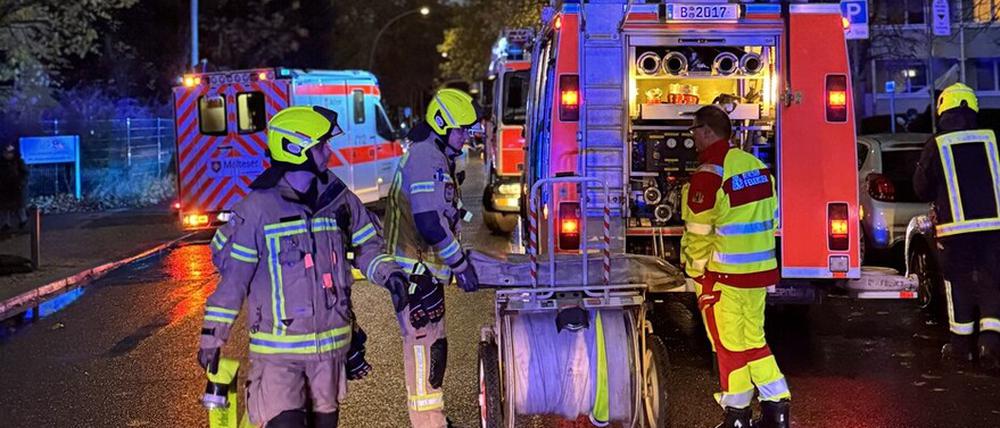 Einsatzkräfte am Löschfahrzeug vor dem Haus in der Habersaathstraße.
