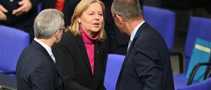 Bärbel Bas (M, SPD), Bundesministerin für Arbeit und Soziales, und Bundeskanzler Friedrich Merz (r, CDU) geben sich vor der Regierungserklärung zum EU-Gipfel im Bundestag die Hand. 