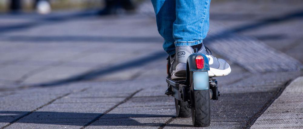 Ein Reisender fährt mit seinem E-Scooter über den Bahnsteig. +