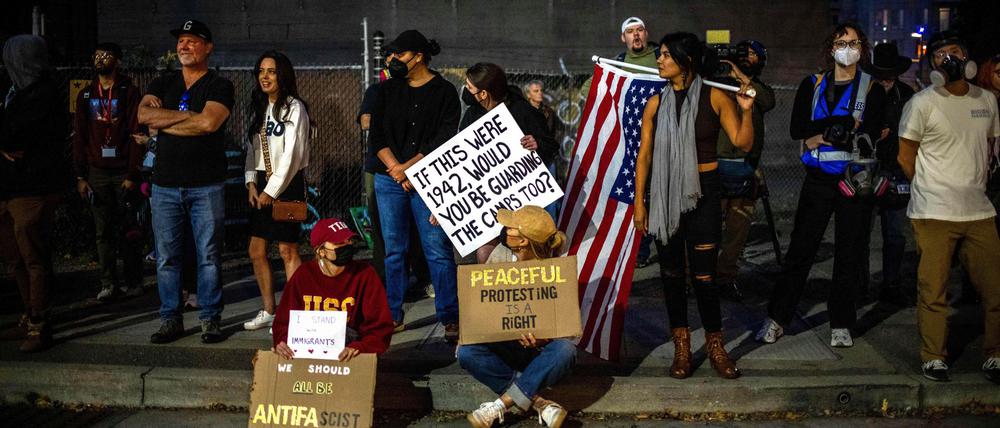 USA, Portland: Demonstranten mit Fahnen und Schildern stehen vor einer Einrichtung der US-Einwanderungsbehörde in Portland. (Archivbild)