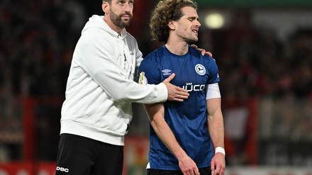 Bielefelds-Trainer Kniat tröstet seinen Spieler Corboz (r.)