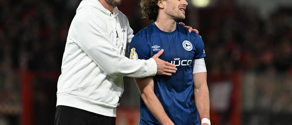 Bielefelds-Trainer Kniat tröstet seinen Spieler Corboz (r.)