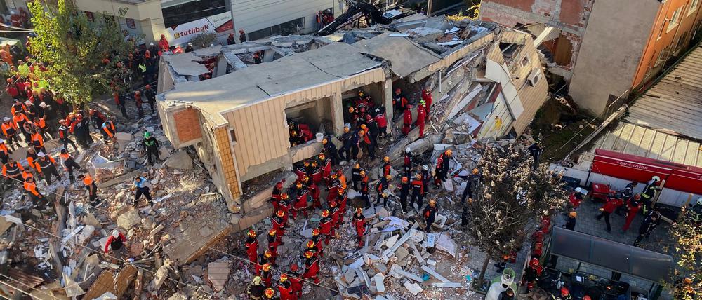 Feuerwehrleute und Rettungskräfte suchen nach dem Einsturz eines Wohngebäudes nach Verschütteten.