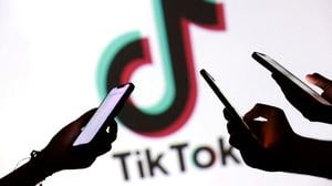 Hände mit Smartphones vor Tiktok-Logo.