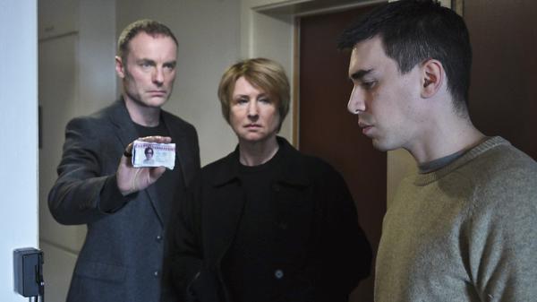 „Tatort“ aus Berlin: Susanne Bonard (Corinna Harofuch, mitte) und Robert Karow (Mark Waschke, li) suchen die Adresse des Toten auf und treffen dort auf seinen Bruder Luis (Henry Morales, re). 