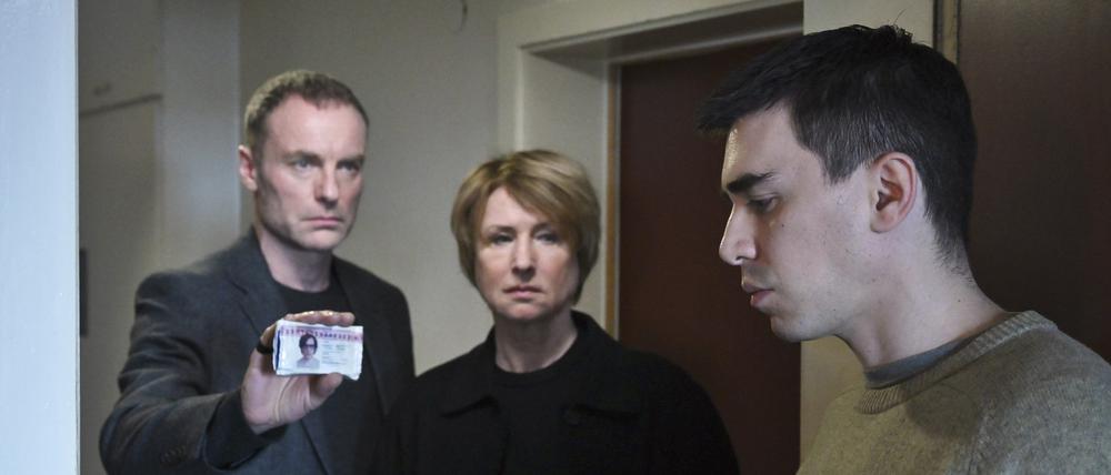 „Tatort“ aus Berlin: Susanne Bonard (Corinna Harofuch, mitte) und Robert Karow (Mark Waschke, li) suchen die Adresse des Toten auf und treffen dort auf seinen Bruder Luis (Henry Morales, re). 