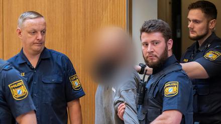 Ein Angeklagter (M) wird zu Beginn des Prozesses gegen ein deutsch-russisches Trio wegen Geheimdiensttätigkeit für Russland und Mitgliedschaft in einer ausländischen Terrorgruppe in den Gerichtssaal geführt.