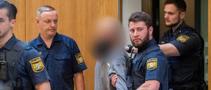 Ein Angeklagter (M) wird zu Beginn des Prozesses gegen ein deutsch-russisches Trio wegen Geheimdiensttätigkeit für Russland und Mitgliedschaft in einer ausländischen Terrorgruppe in den Gerichtssaal geführt.