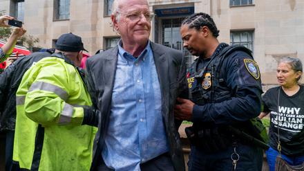 Bei strömendem Regen wird Ben Cohen, Mitbegründer von Ben & Jerry’s, von der Polizei des Heimatschutzministeriums in Gewahrsam genommen, weil er den Eingang zum Justizministerium blockiert hat.  