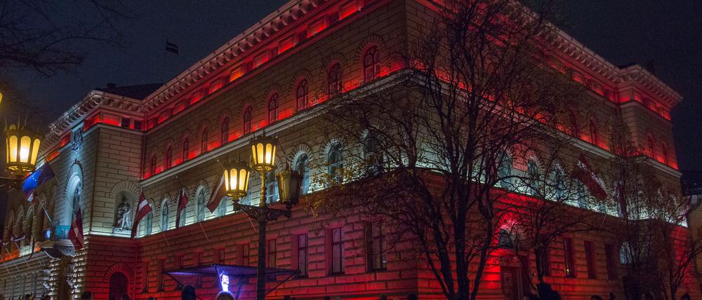 Das lettische Parlament ist in den lettischen Nationalfarben angestrahlt.