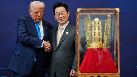 US-Präsident Donald Trump (l) schüttelt dem südkoreanischen Präsidenten Lee Jae Myung die Hand, während er ein Geschenk in Form einer goldenen Krone und einer Verleihung des Großen Mugunghwa-Ordens (nicht im Bild) während einer Zeremonie im Gyeongju National Museum entgegennimmt.