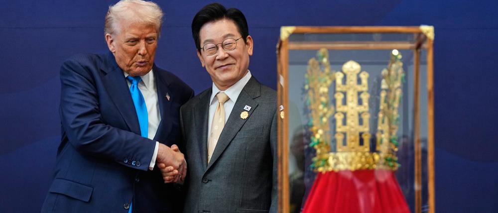 US-Präsident Donald Trump (l) schüttelt dem südkoreanischen Präsidenten Lee Jae Myung die Hand, während er ein Geschenk in Form einer goldenen Krone und einer Verleihung des Großen Mugunghwa-Ordens (nicht im Bild) während einer Zeremonie im Gyeongju National Museum entgegennimmt.