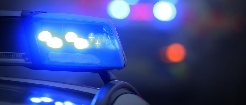 Ein Polizeiauto mit eingeschaltetem Blaulicht steht an einer Unfallstelle. (Symbolbild)