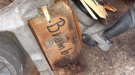 An einem Luxusauto im Neuwert von 100.000 sind Bremsklötze aus Holz befestigt.