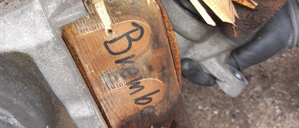 An einem Luxusauto im Neuwert von 100.000 sind Bremsklötze aus Holz befestigt.