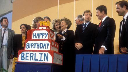 US-Präsident Ronald Reagan überreicht als Geburtstagsgeschenk an die Stadt Berlin eine Torte im Flughafen Tempelhof am 12. Juni 1987.