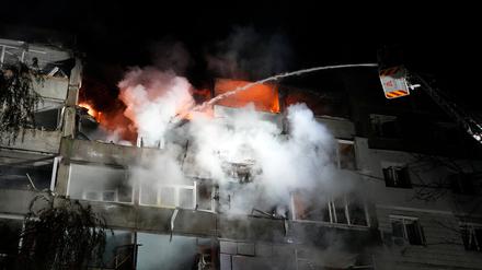 Ein Feuerwehrmann löscht ein Feuer in einem Wohnhaus in Sumy, das während eines russischen Drohnenangriffs getroffen wurde (Symbolbild).