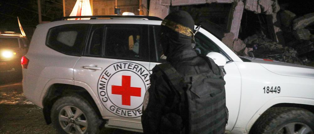Ein bewaffneter Mann in der Uniform der al-Qassam-Brigaden, dem militärischen Flügel der Hamas, steht Wache, als Fahrzeuge des Roten Kreuzes ein Lagerhaus verlassen (Symbolfoto).