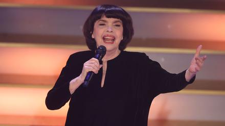 Mit Chanel-Hut und chinesischem Sonnenschirm schützt Chanson-Legende Mireille Mathieu ihre Haut. (Archivbild)