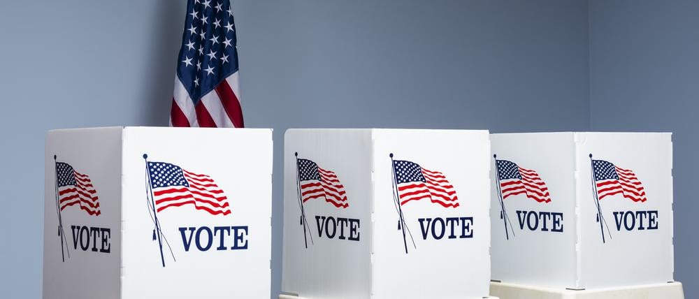 Wahlurnen vor einer US-Flagge