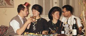 Lockerungsübungen mit Alkohol: Paare stoßen 1958 bei einer Silvester-Party miteinander an. 