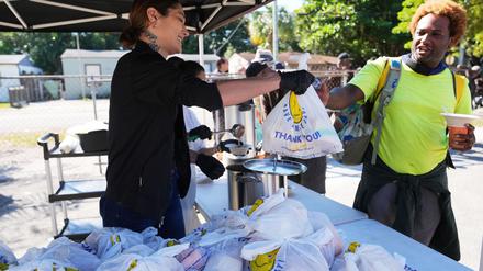 Die freiwillige Helferin Antonia Uribe (l) verteilt Tüten mit Lebensmitteln bei einer Lebensmittelausgabe der Village (FREE)DGE im Freedom Lab, einer gemeinnützigen Initiative.