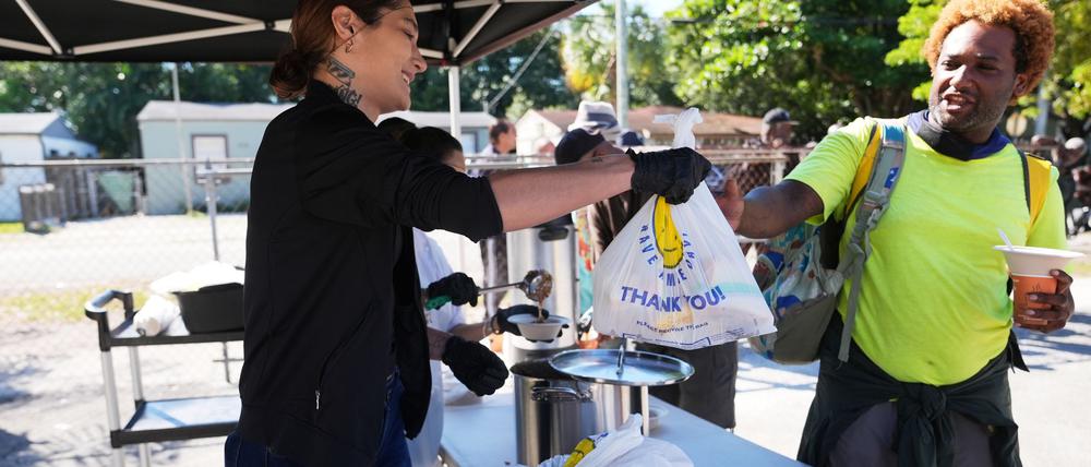 Die freiwillige Helferin Antonia Uribe (l) verteilt Tüten mit Lebensmitteln bei einer Lebensmittelausgabe der Village (FREE)DGE im Freedom Lab, einer gemeinnützigen Initiative. 