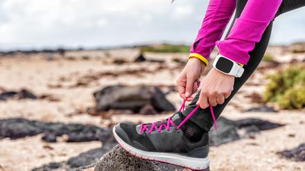 Eine Frau schnürt sich die Laufschuhe (Symbolbild).