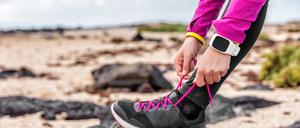 Eine Frau schnürt sich die Laufschuhe (Symbolbild).