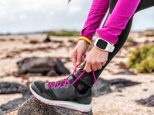 Eine Frau schnürt sich die Laufschuhe (Symbolbild).