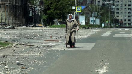 Eine ältere Bewohnerin Pokrowsks geht am 21. Mai 2025 durch eine zerstörte Straße.