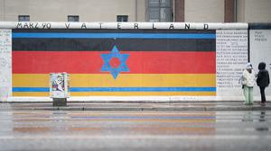 Das Mauerbild "Vaterland" ist auf den Resten der Berliner Mauer, der East Side Gallery, zu sehen. Das Bild wurde in der Nacht durch arabische Schriftzüge mit Bezug zum Nahostkonflikt beschmiert, aber bereits wieder gereinigt. +++ dpa-Bildfunk +++