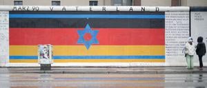 Das Mauerbild "Vaterland" ist auf den Resten der Berliner Mauer, der East Side Gallery, zu sehen. Das Bild wurde in der Nacht durch arabische Schriftzüge mit Bezug zum Nahostkonflikt beschmiert, aber bereits wieder gereinigt. +++ dpa-Bildfunk +++