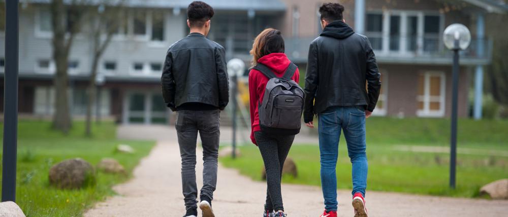 Drei jugendliche syrische Flüchtlinge gehen in Dahlem bei Dahlenburg (Niedersachsen) auf dem Gelände des Internatsgymnasiums Marienau zum Unterricht.