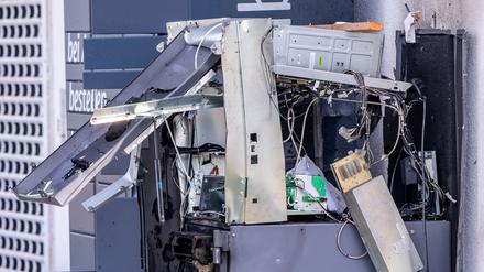 Ein gesprengter Geldautomat steht vor einem Getränkemarkt und wird von der Polizei untersucht.