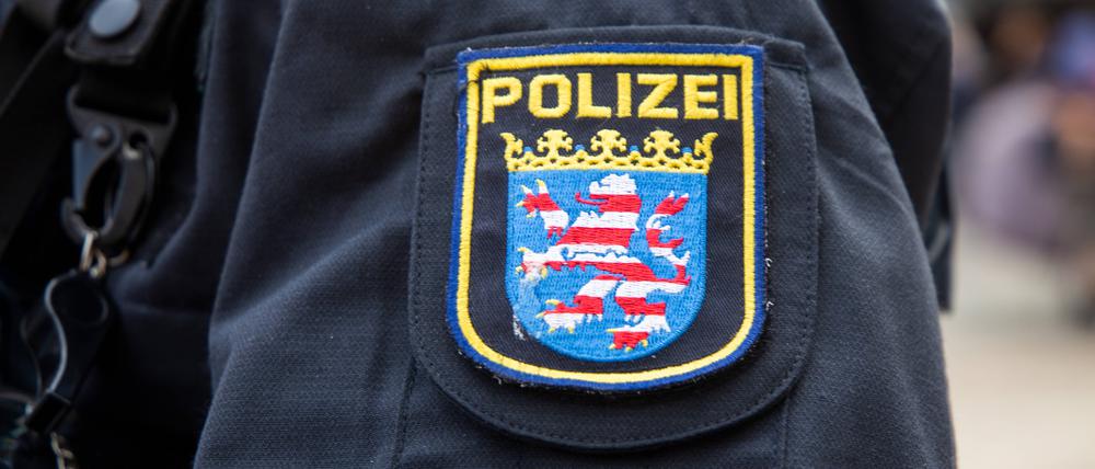 Das Wappen der Polizei Hessen ist auf der Dienstkleidung eines Polizisten zu sehen.