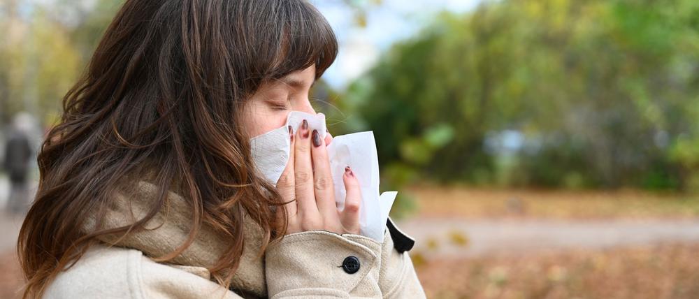 Wer niesen muss, sollte sich von anderen Personen abwenden und ein Taschentuch oder die Armbeuge vor Mund und Nase halten (Symbolbild).
